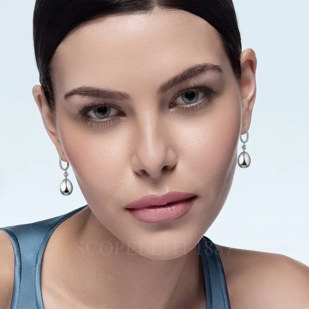 woman wearing fabergé essence white gold diamond set egg drop earrings