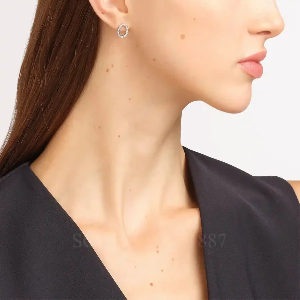woman wearing fabergé sasha white gold diamond egg earrings