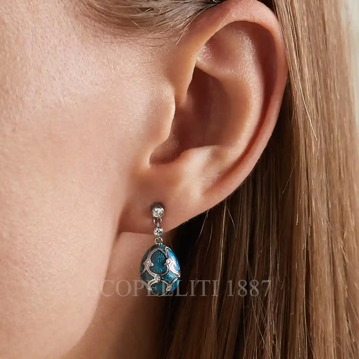 woman wearing fabergé 18kt white gold teal egg drop earrings