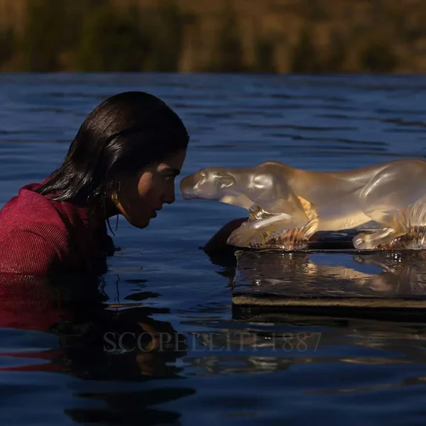 woman staring at lalique lioness timbavati sculpture