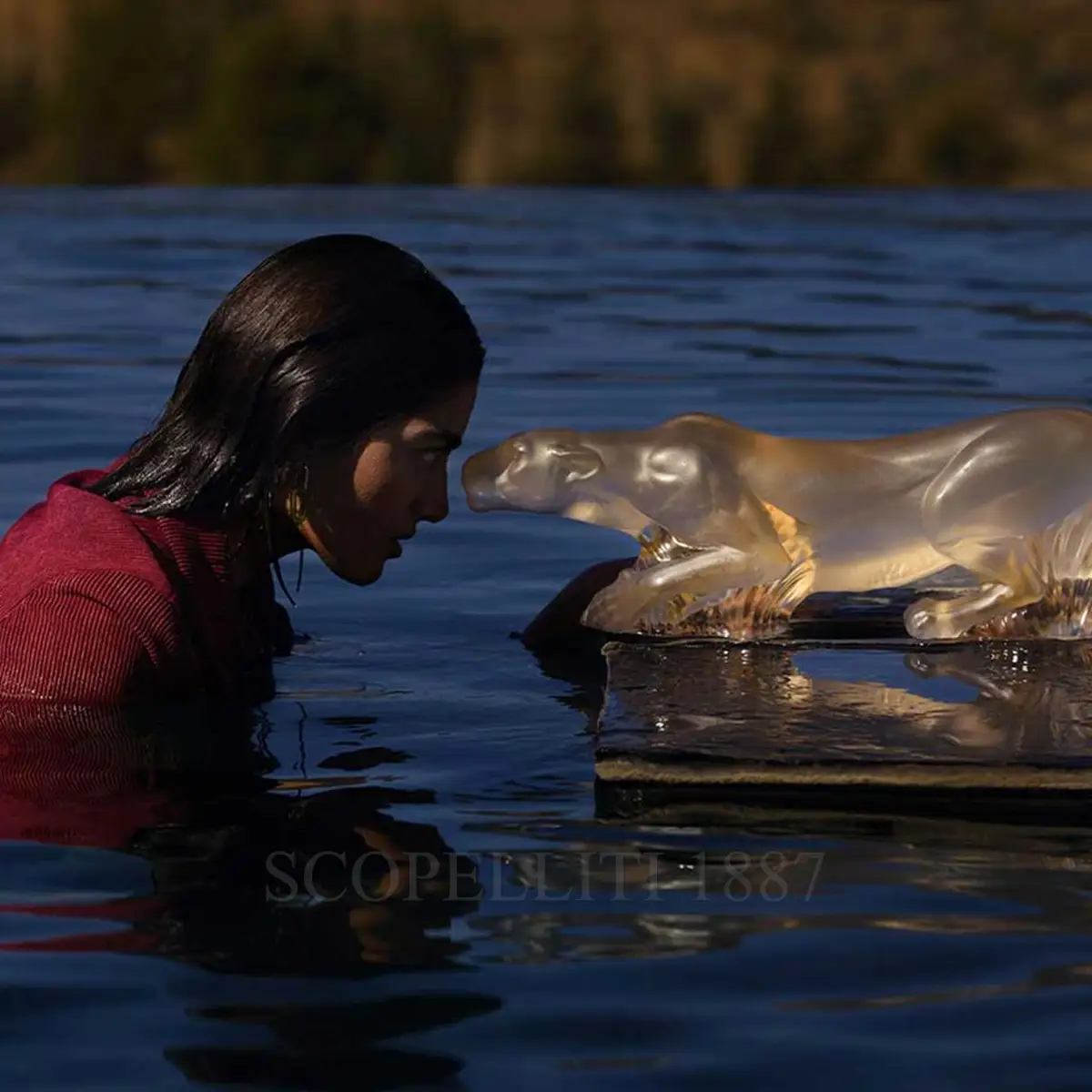 woman staring at lalique lioness timbavati sculpture